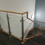 Stainless steel balustrade with timber top rail and 10mm toughened glass infill panels