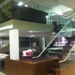 Mezzanine floor with staircase and frameless glass balustrade at Birmingham Airport