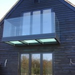 Black powder coated balcony with frosted triple glazed floor and frameless glass balustrade
