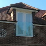 Prefixed juliette balcony shaped around guttering, held in place with 6 nr stainless steel glass adaptors
