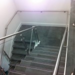 Stainless steel balustrade with glass infill panels and wall rail