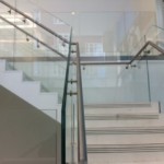 Steel staircase finished in terrazzo with frameless glass balustrade