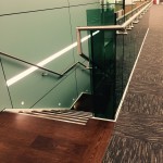 Steel staircase at MTC with frameless glass balustrade and timber treads and landings