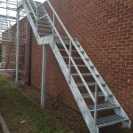 Steel fire escape stairs with open grille treads, galvanised finish