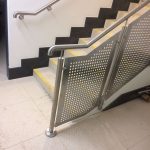 Stainless steel balustrade with perforated infill panels and matching wall rail to staircase