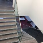 Steel staircase with double stringers, frameless glass balustrade, stainless steel handrail