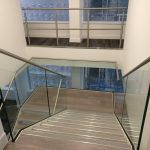 Steel staircase with double stringers, frameless glass balustrade, stainless steel handrail