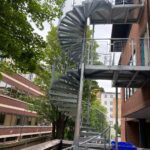 Galvanised steel spiral staircase with welded wire mesh infill panels